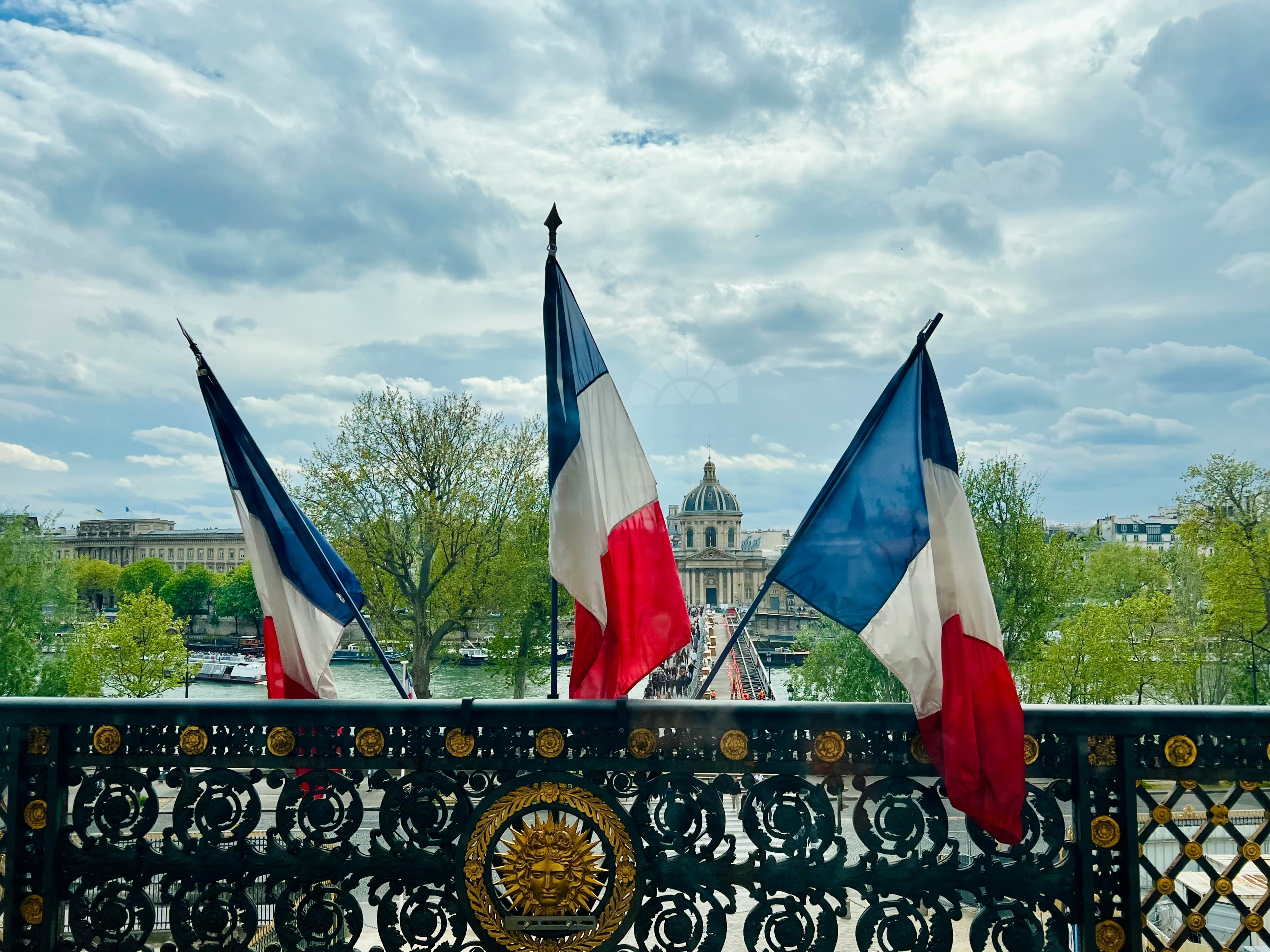 Photo de drapeaux français sur la façade d'une mairie : quel niveau de français est requis en 2026 pour la carte de résident ?